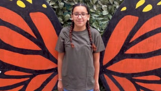 Uvalde girl posing with monarch butterfly wings.